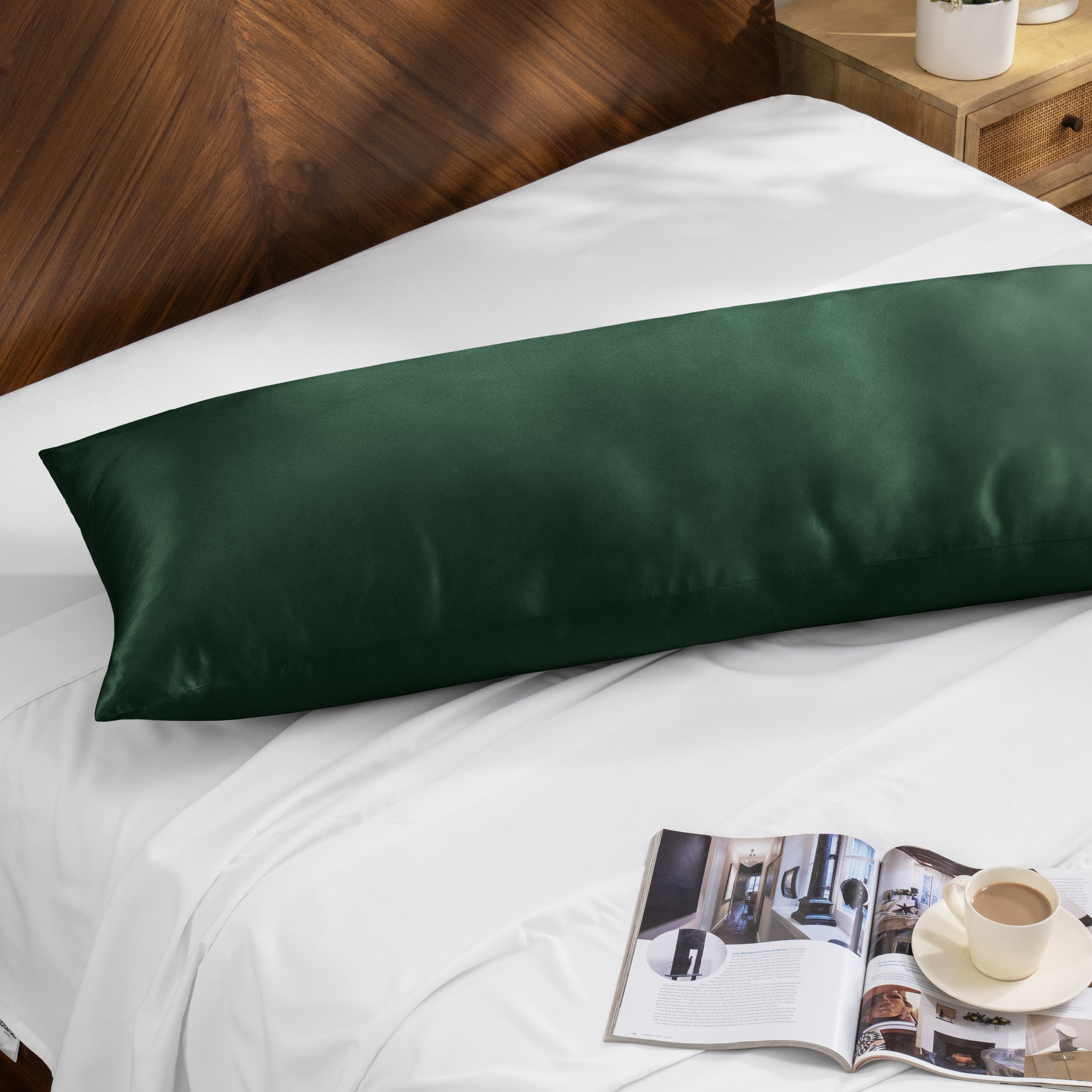 Bamboo body pillow on a bed with a magazine and cup of coffee nearby.