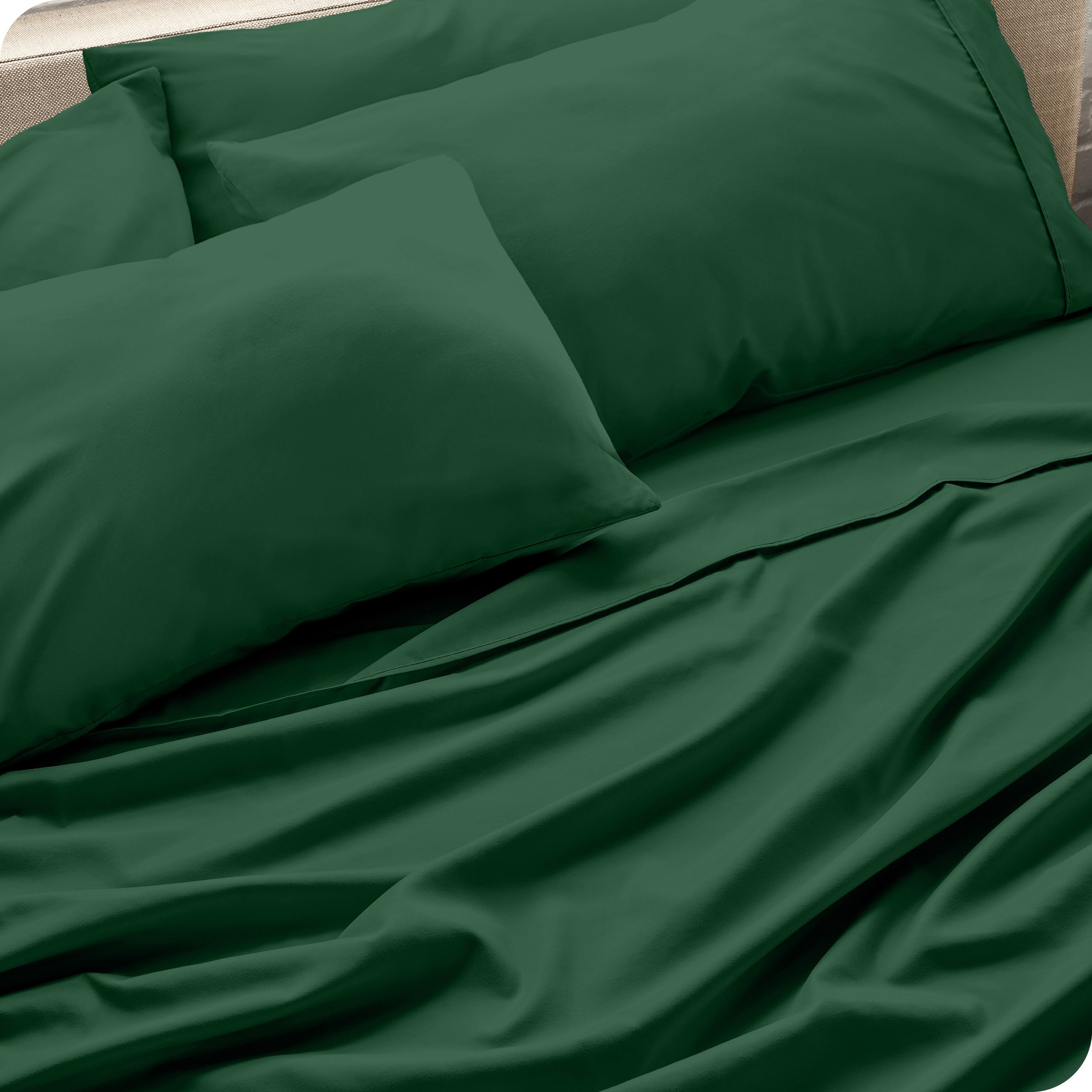Close up of the microfiber bed sheets on a bed with four pillows.