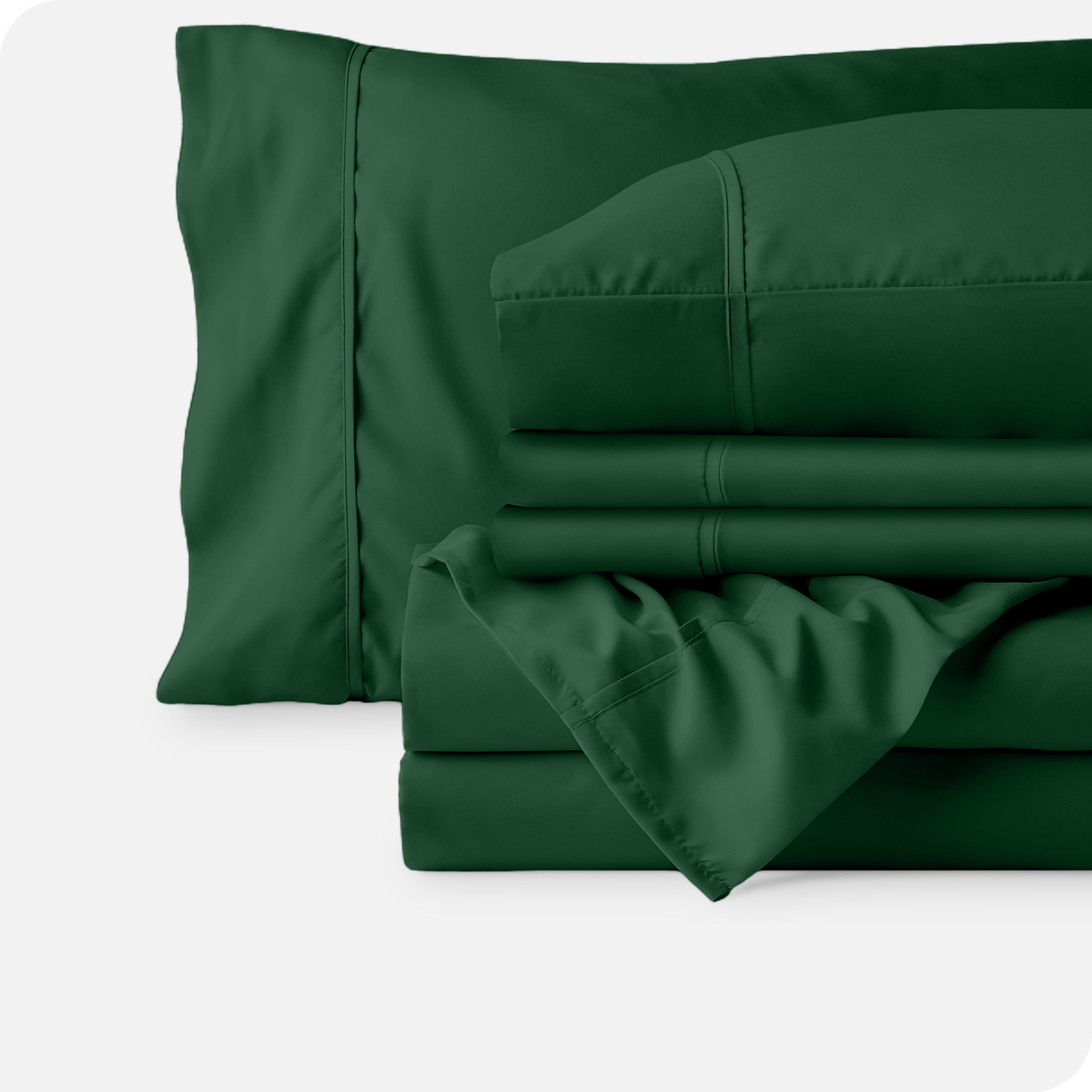 Microfiber sheets neatly folded with corner draped over, two folded pillowcases and two display pillows.