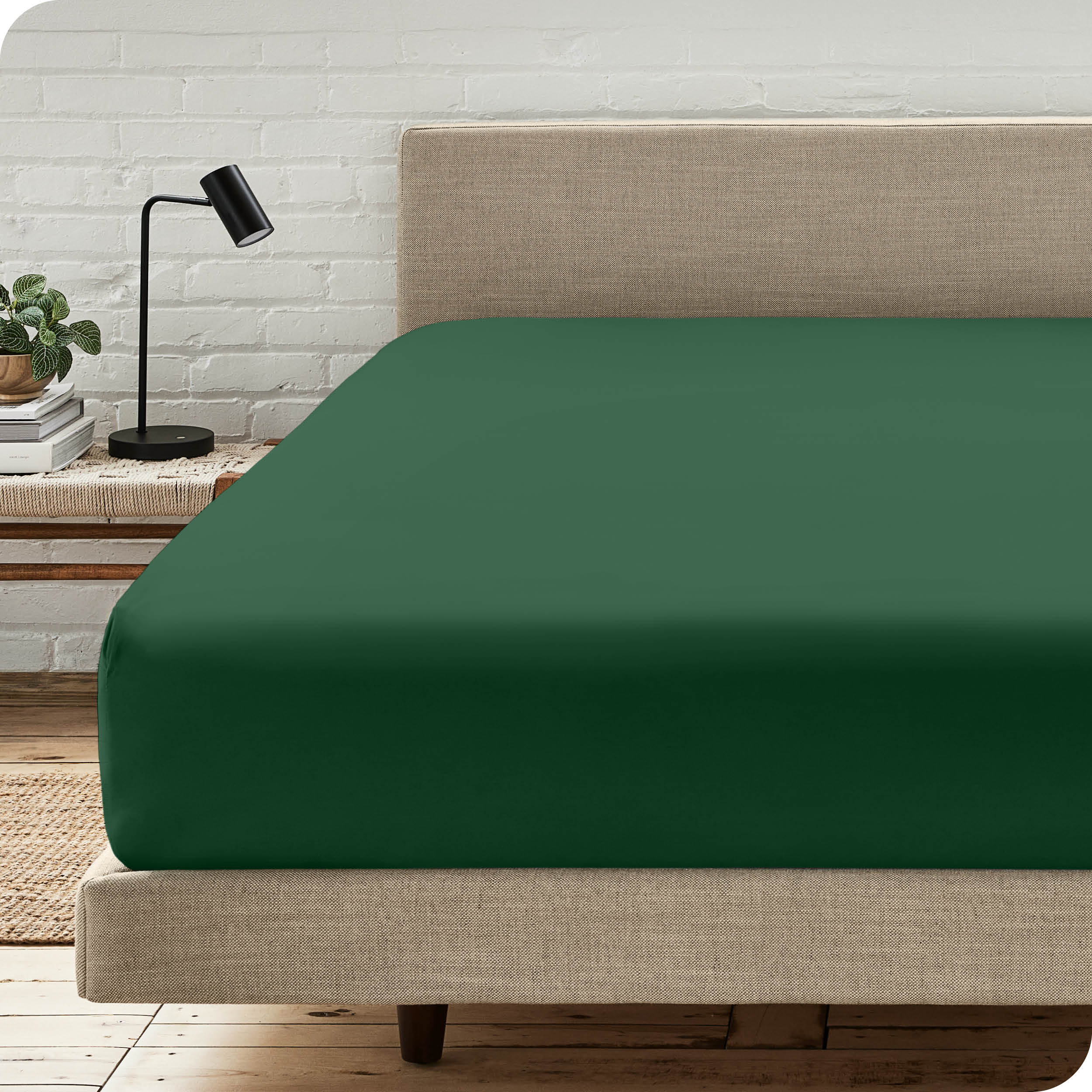 A bed with a microfiber fitted sheet on the mattress. 