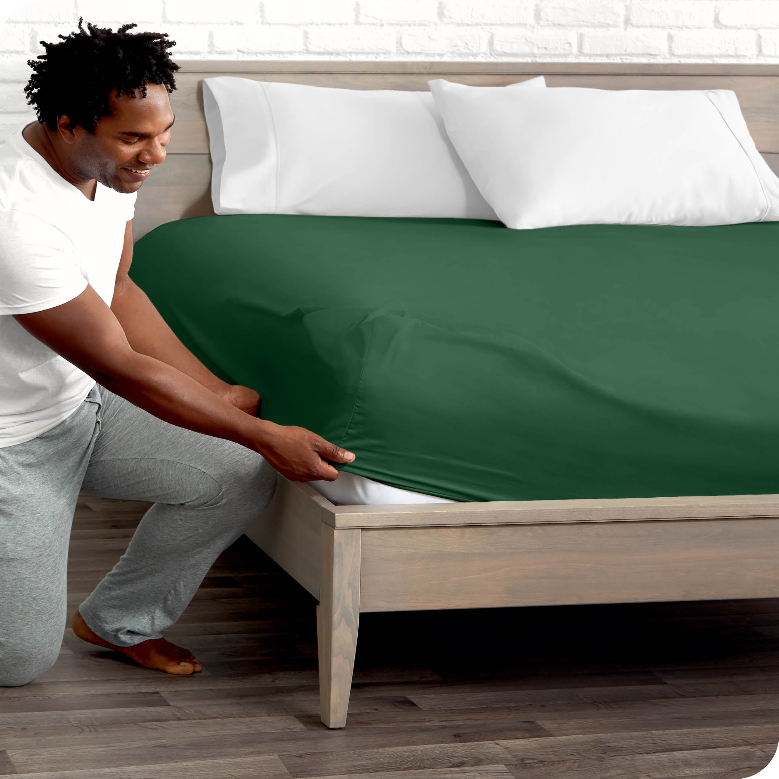 A man putting the microfiber fitted sheet on a mattress. 