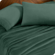 Two pillows with pillowcases on them set on a bed with matching sheets