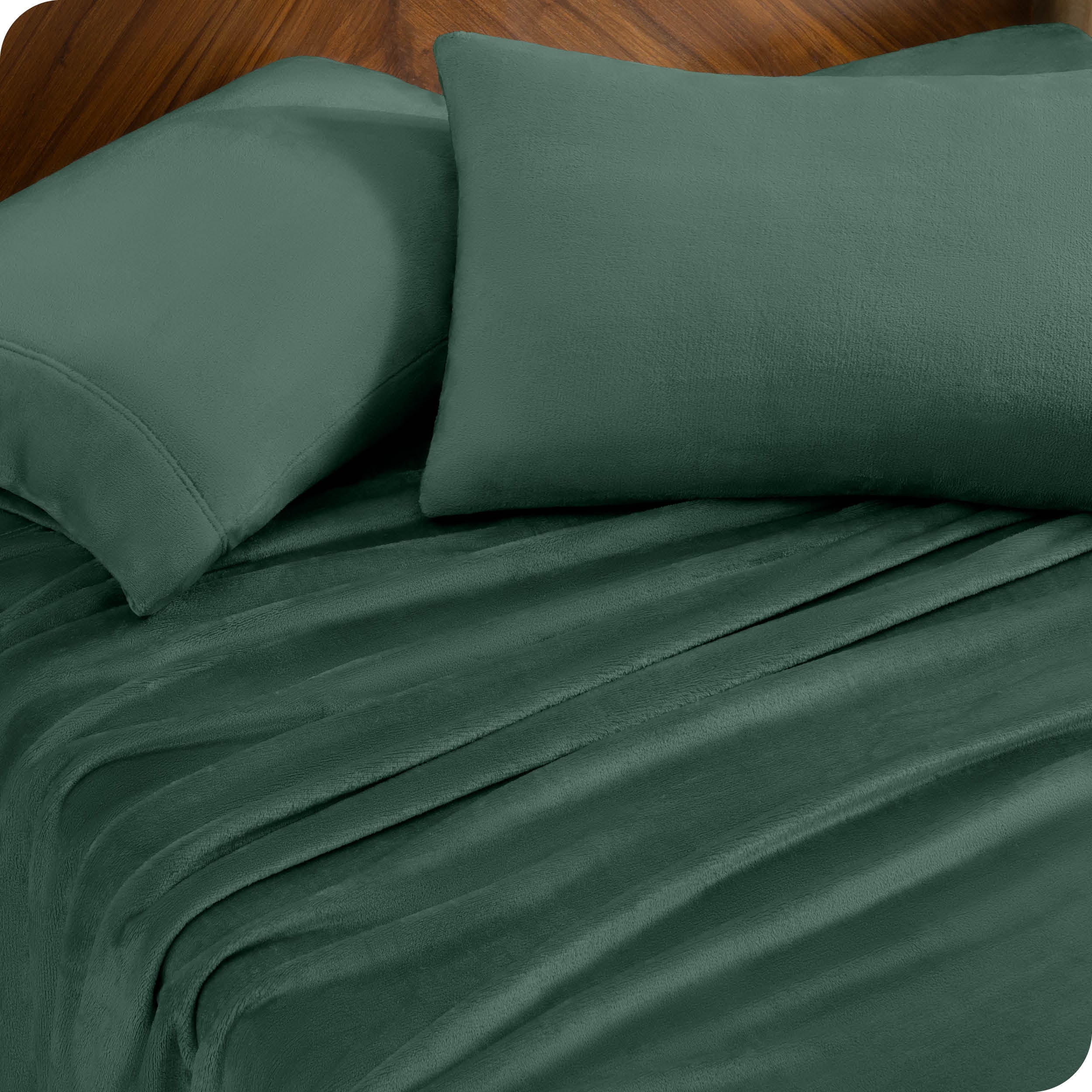 Two pillows with pillowcases on them set on a bed with matching sheets