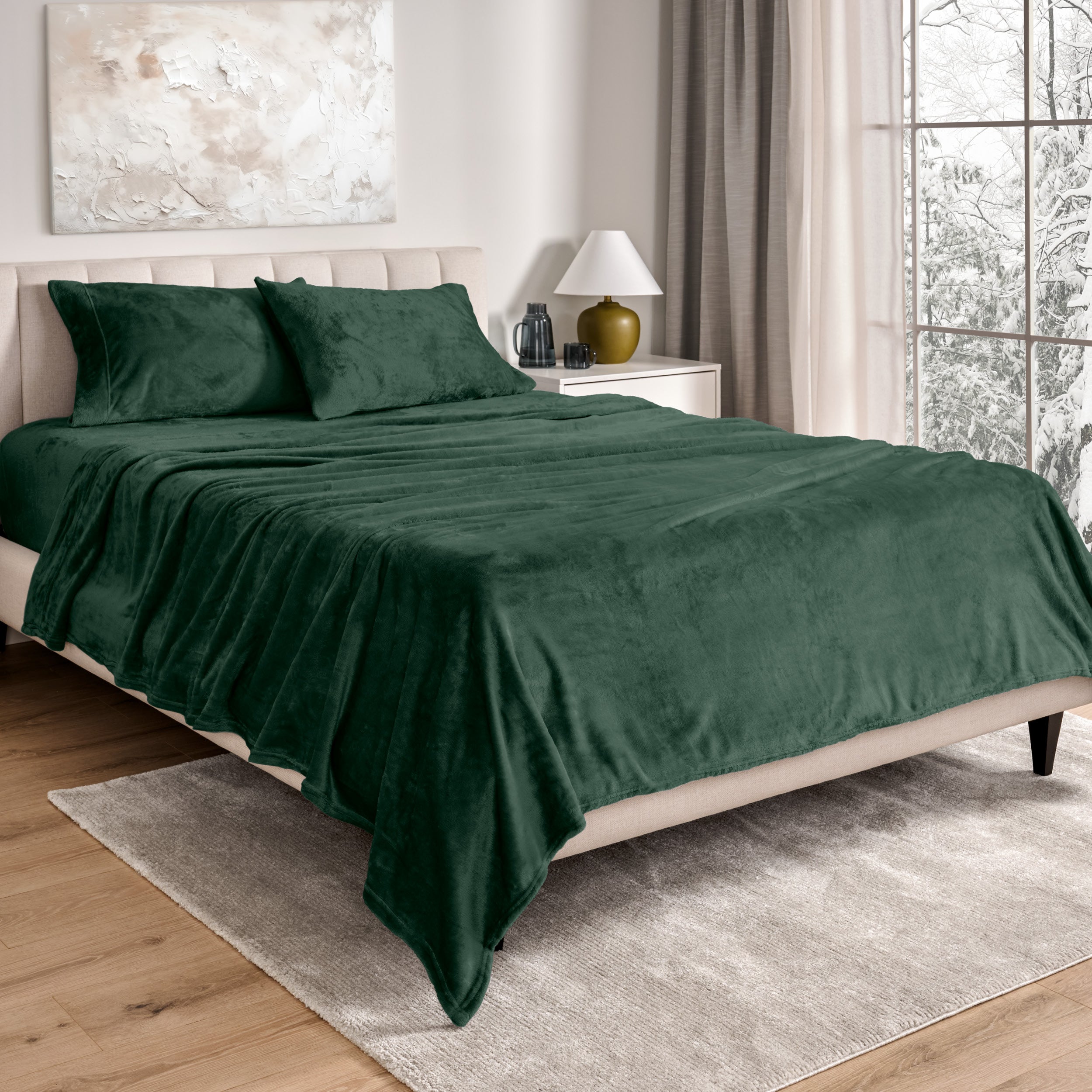 Sheets and matching pillowcases on a bed in a bedroom with a lamp and window in the background.