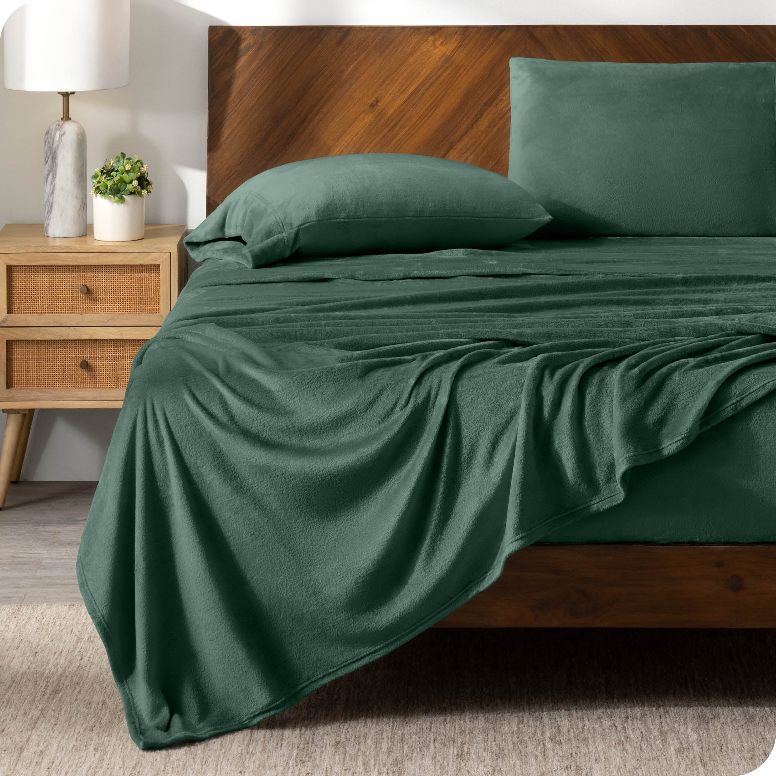 A black sheet set on a bed with a wooden bed frame