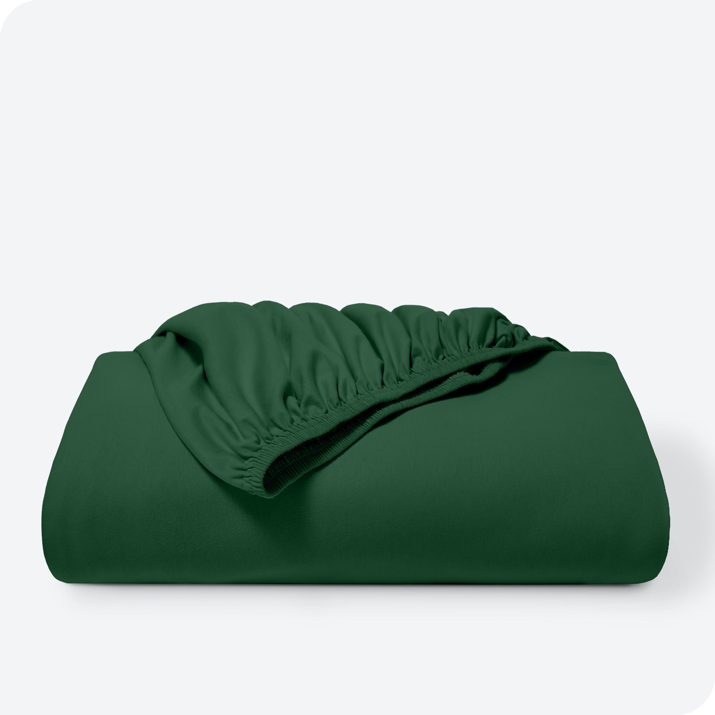 A bed made with a cotton jersey fitted sheet with 2 pillows near the headboard