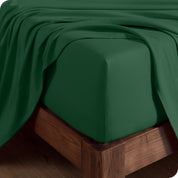 Close up of the corner of a mattress with a fitted sheet and flat sheet on it
