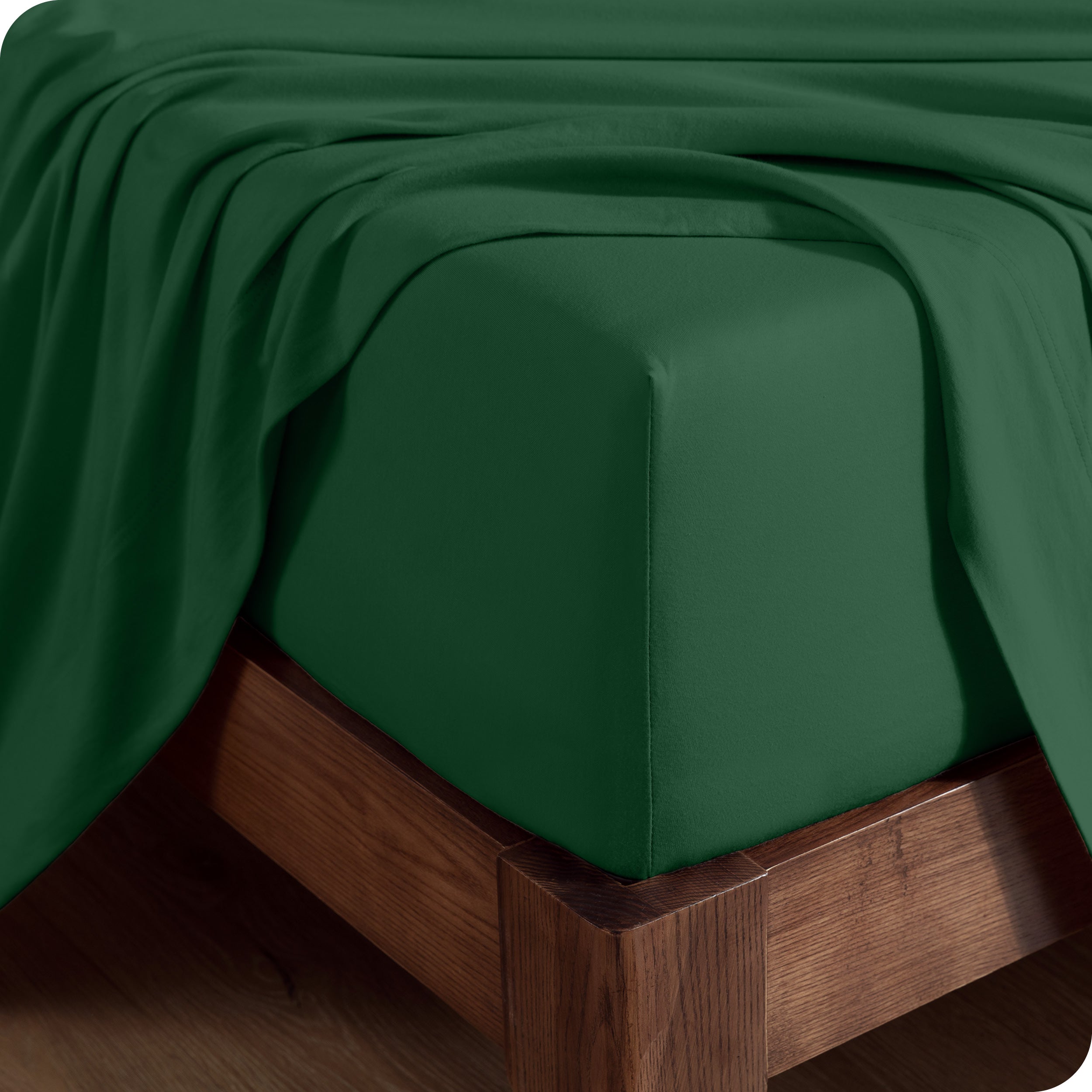 Close up of the corner of a mattress with a fitted sheet and flat sheet on it