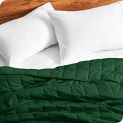 Close up of a weighted blanket on a bed with  2 pillows