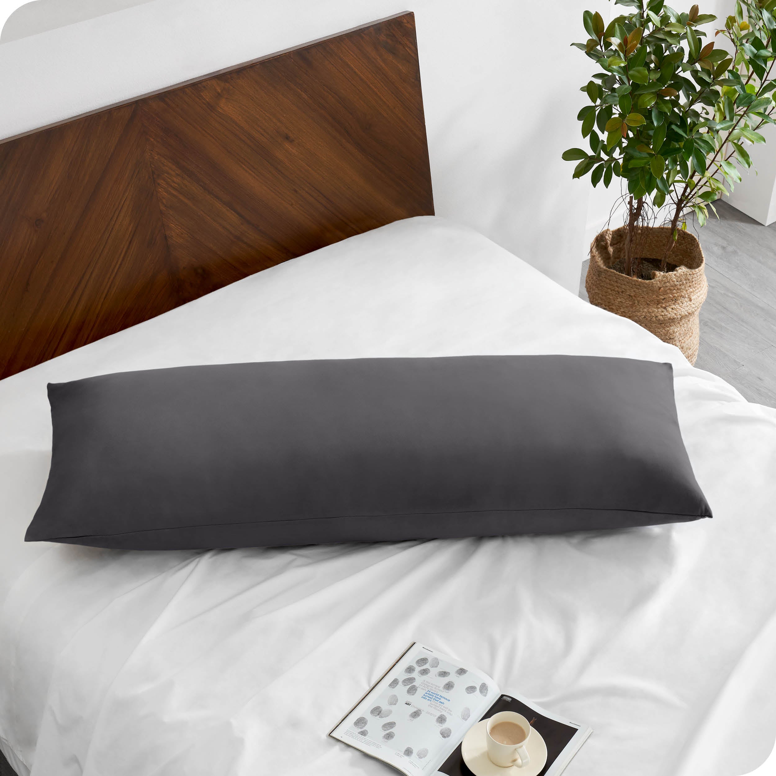 A body pillowcase on a pillow on a bed with all white bedding