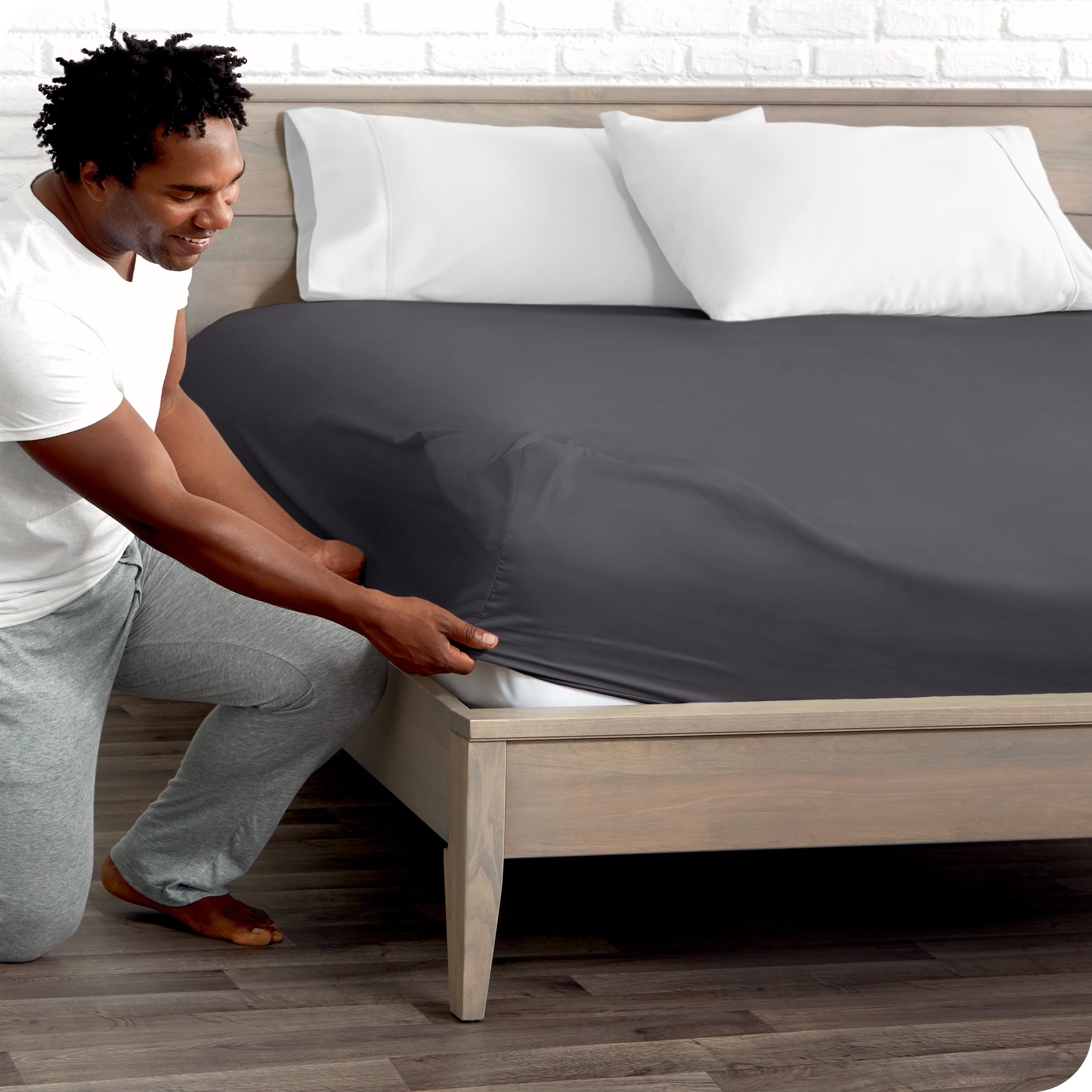 A man putting the microfiber fitted sheet on a mattress. 