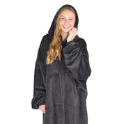An adult is standing while wearing a microplush wearable blanket