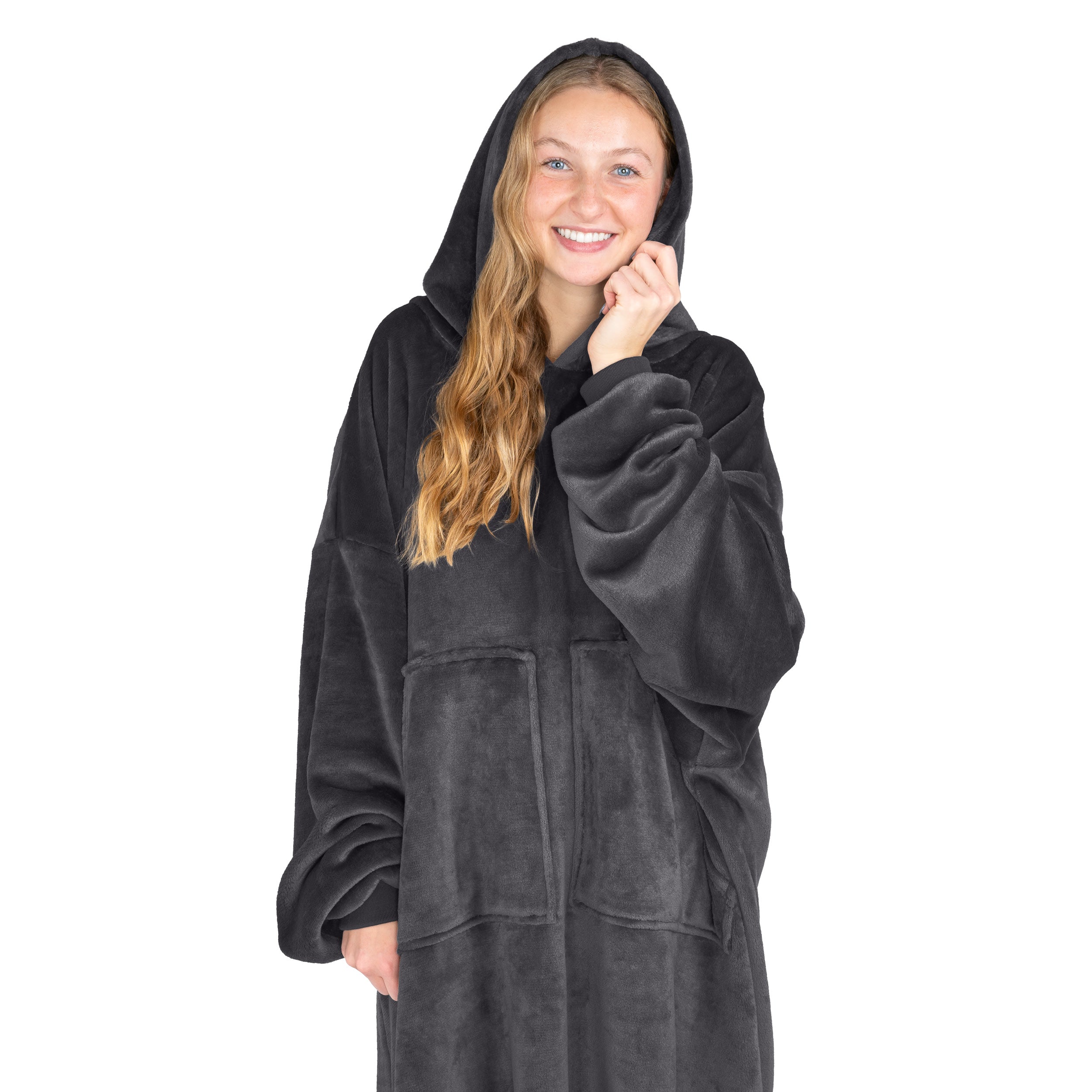 An adult is standing while wearing a microplush wearable blanket
