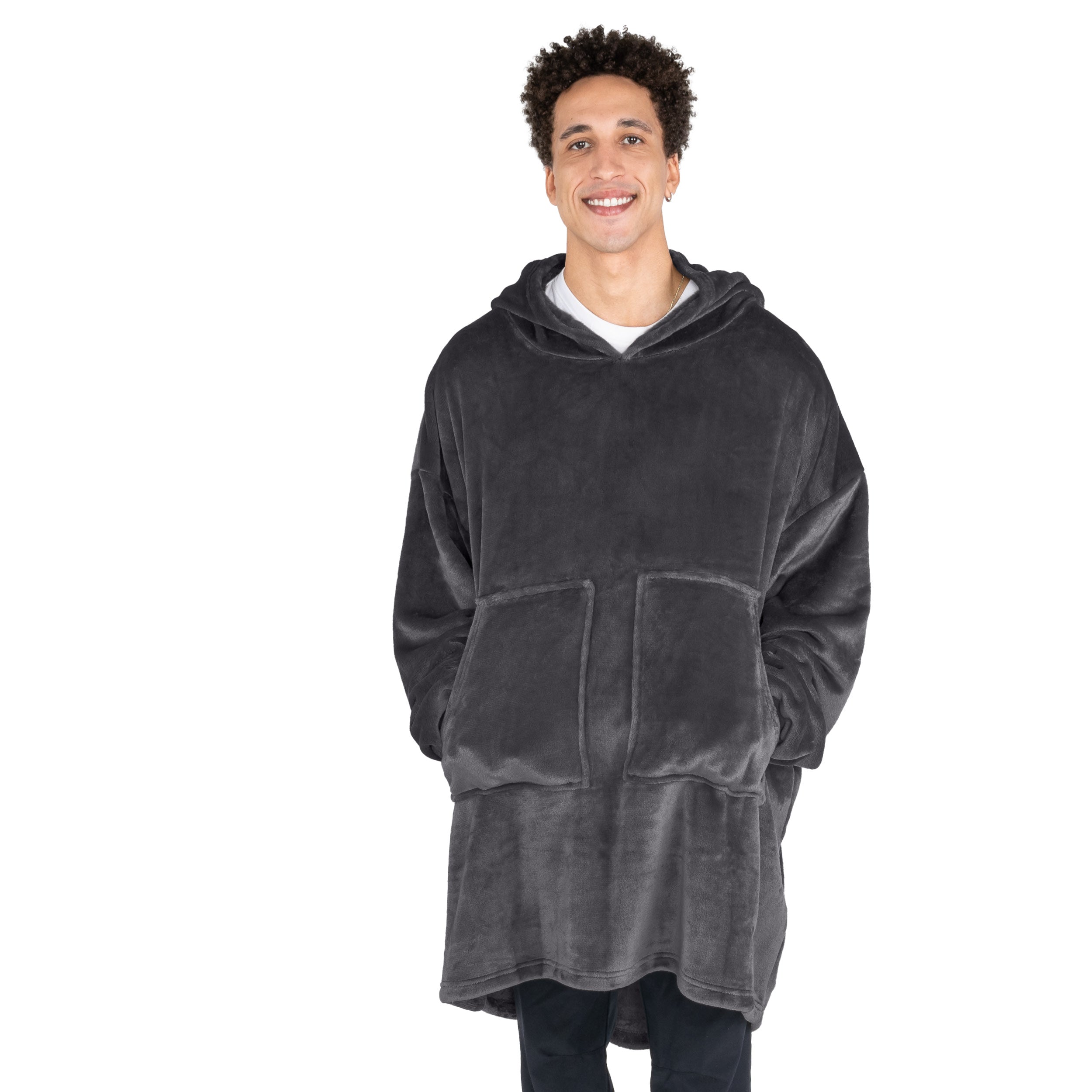 A man with his hands in the pockets of the wearable blanket he has on