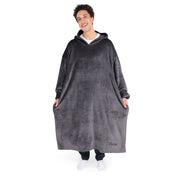 An adult is standing while wearing a long microplush wearable blanket