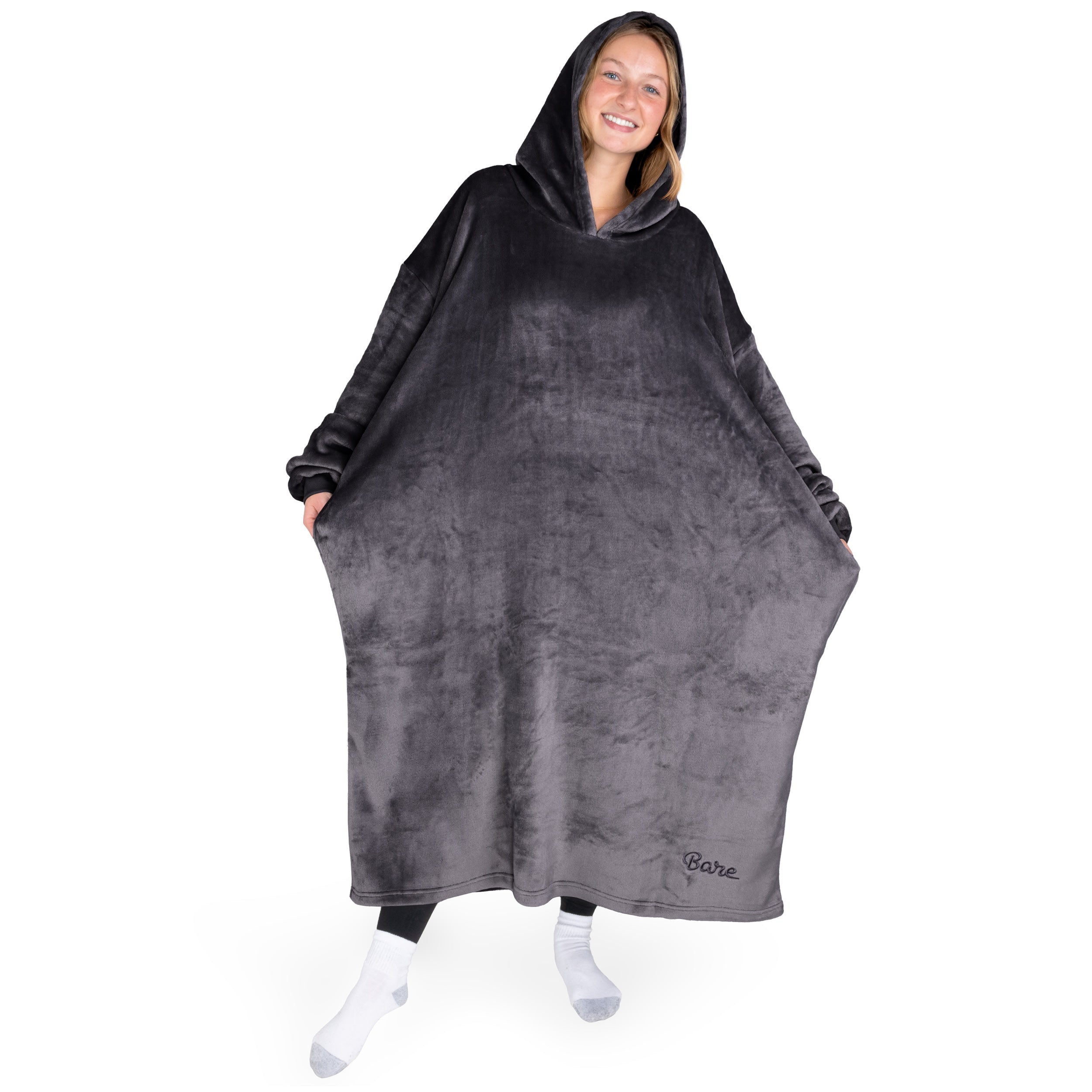 An adult with long microplush wearable blanket on