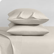 Two sateen pillowcases stacked on a bed