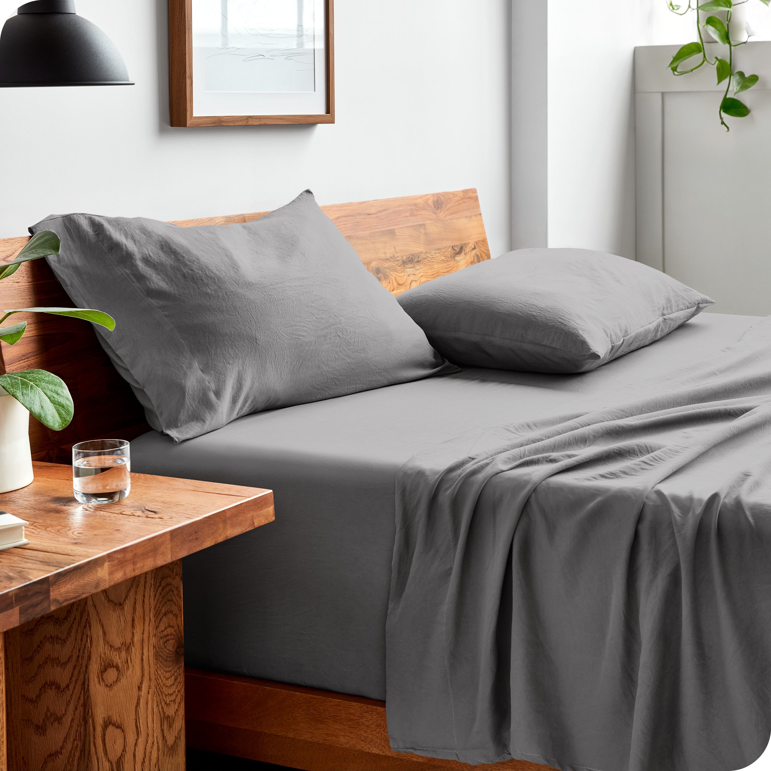Side view of bed made with fitted sheet, pillowcases, and top sheet