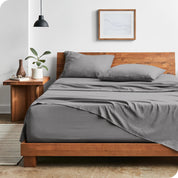 Modern bedroom with Sandwashed sheets draped over the end and side of mattress
