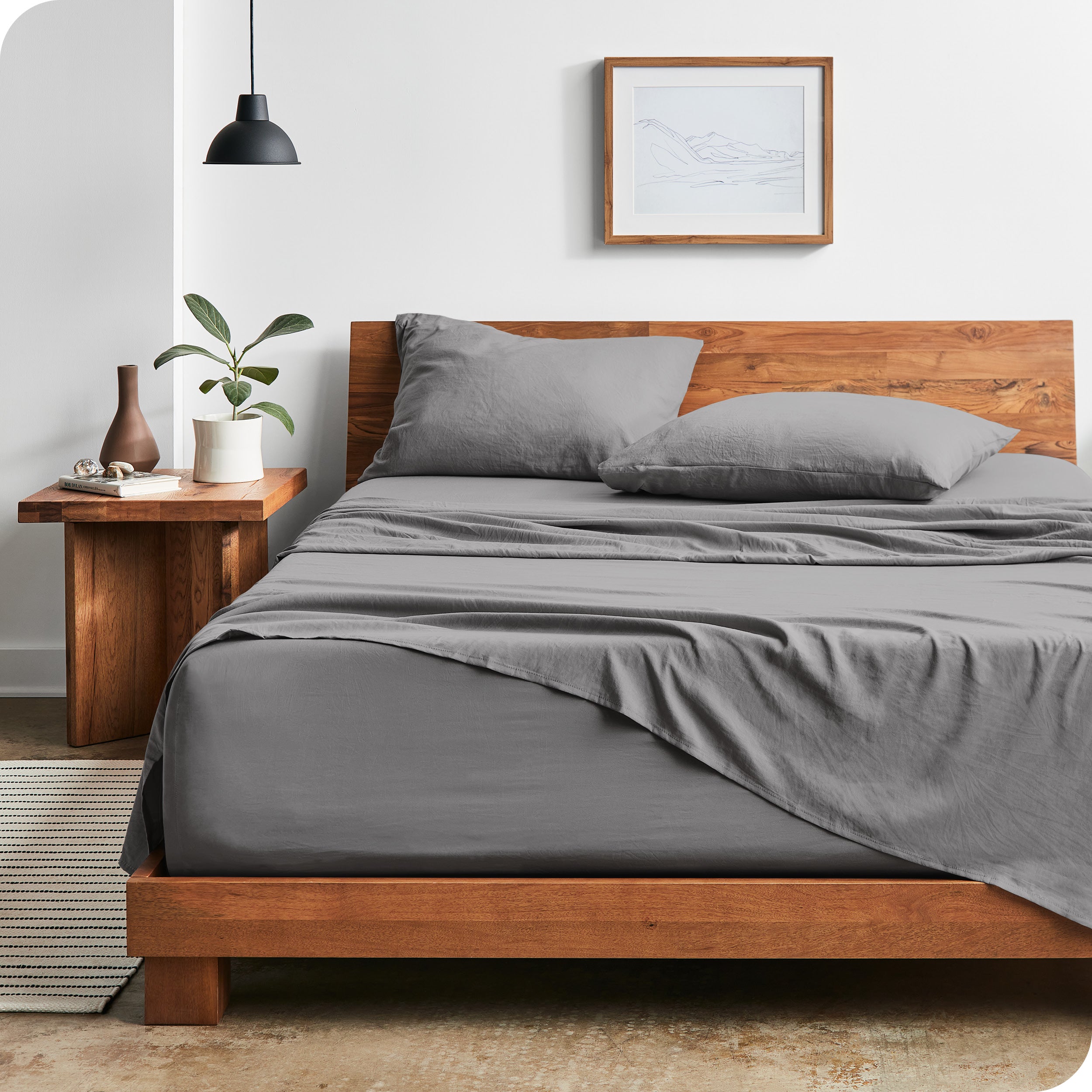 Modern bedroom with Sandwashed sheets draped over the end and side of mattress
