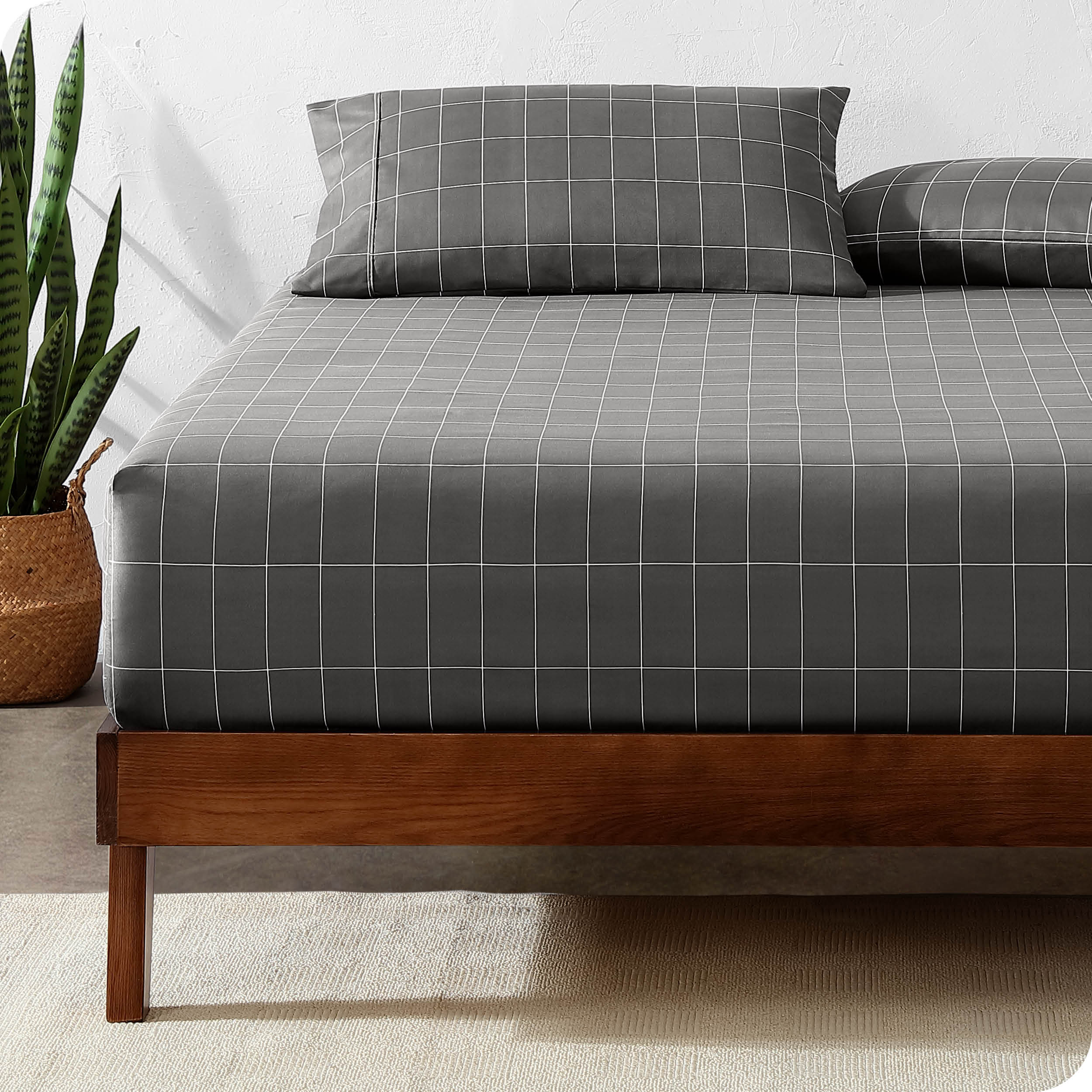 View for the end of a modern bed with a printed microfiber fitted sheet made with pillows. 