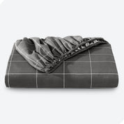 A neatly folded printed microfiber fitted sheet with elastic draped. 
