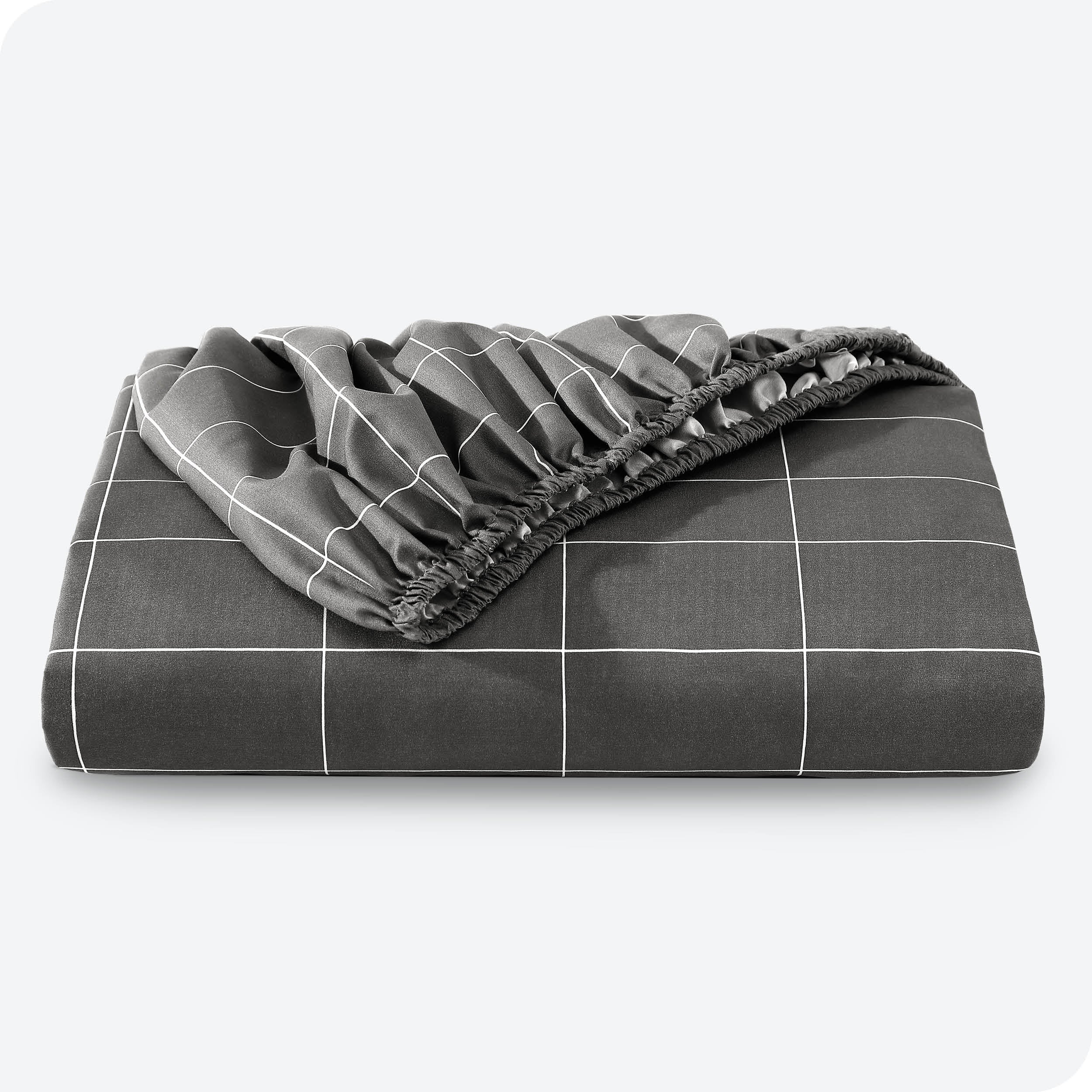 A neatly folded printed microfiber fitted sheet with elastic draped. 