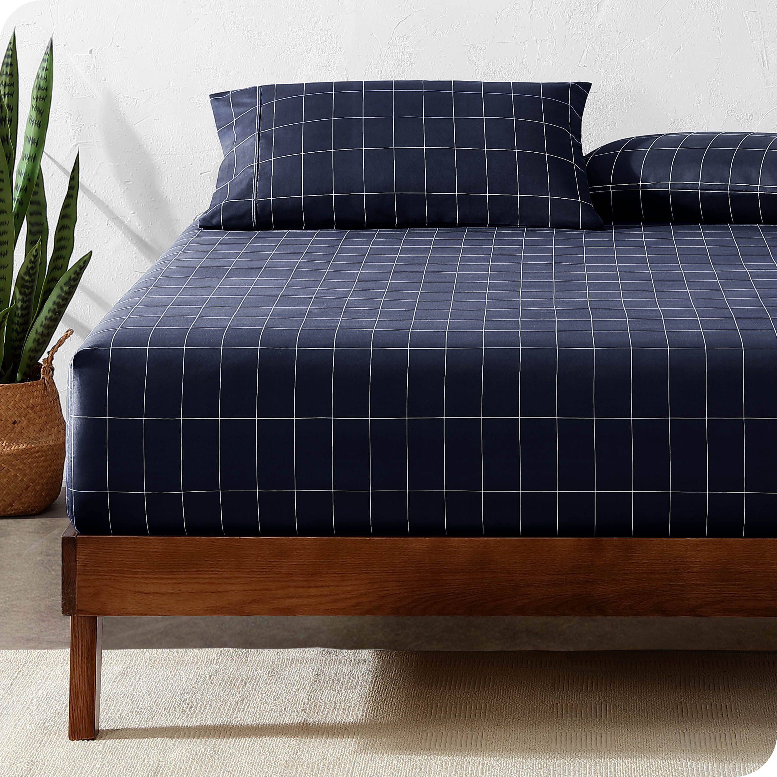 View for the end of a modern bed with a printed microfiber fitted sheet made with pillows. 