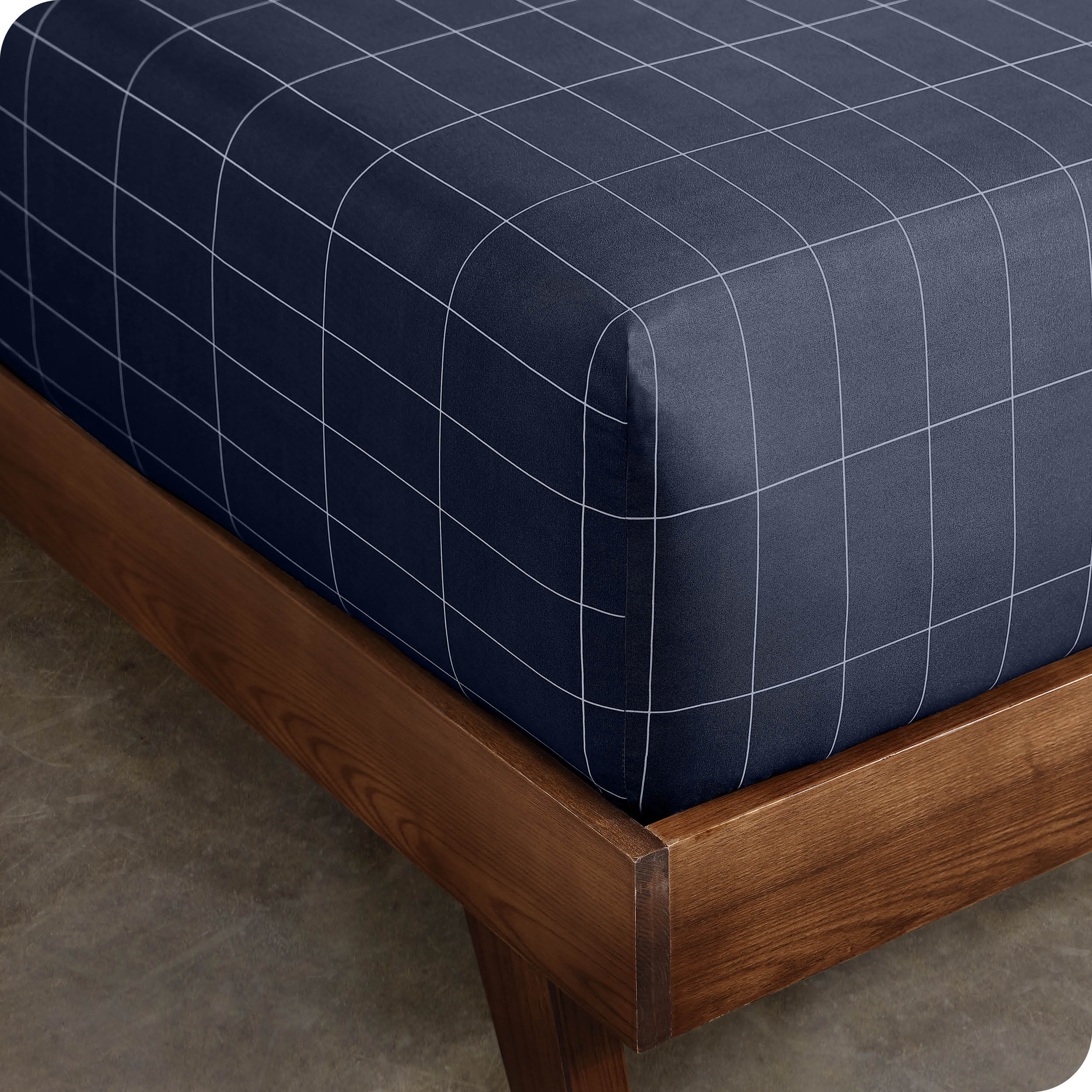 Close up view of the corner of a mattress with the microfiber fitted sheet to show how it fits. 