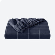 A neatly folded printed microfiber fitted sheet with elastic draped. 