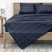 View from the end of a modern bed made with a microfiber sheet set with a modern print. 