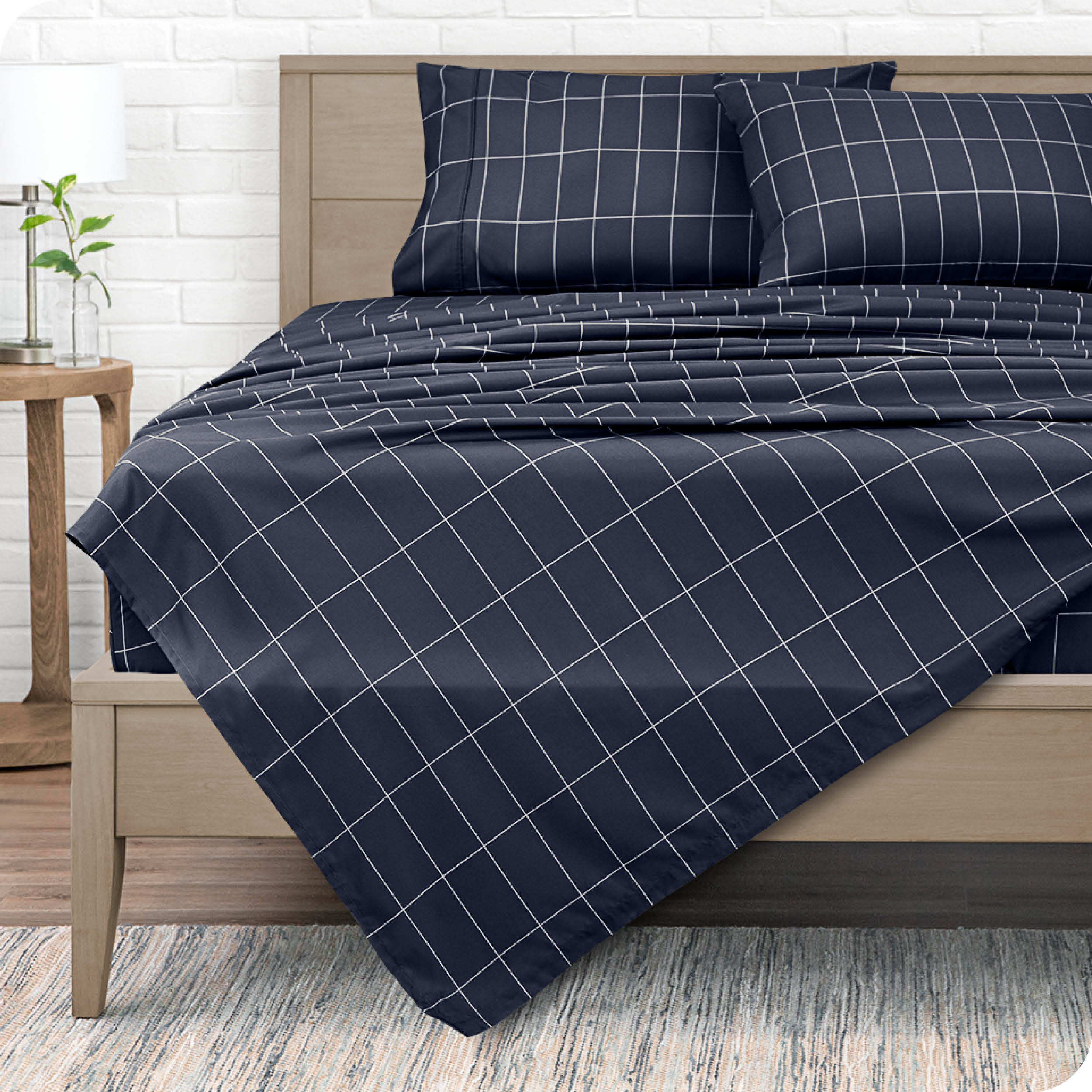 View from the end of a modern bed made with a microfiber sheet set with a modern print. 