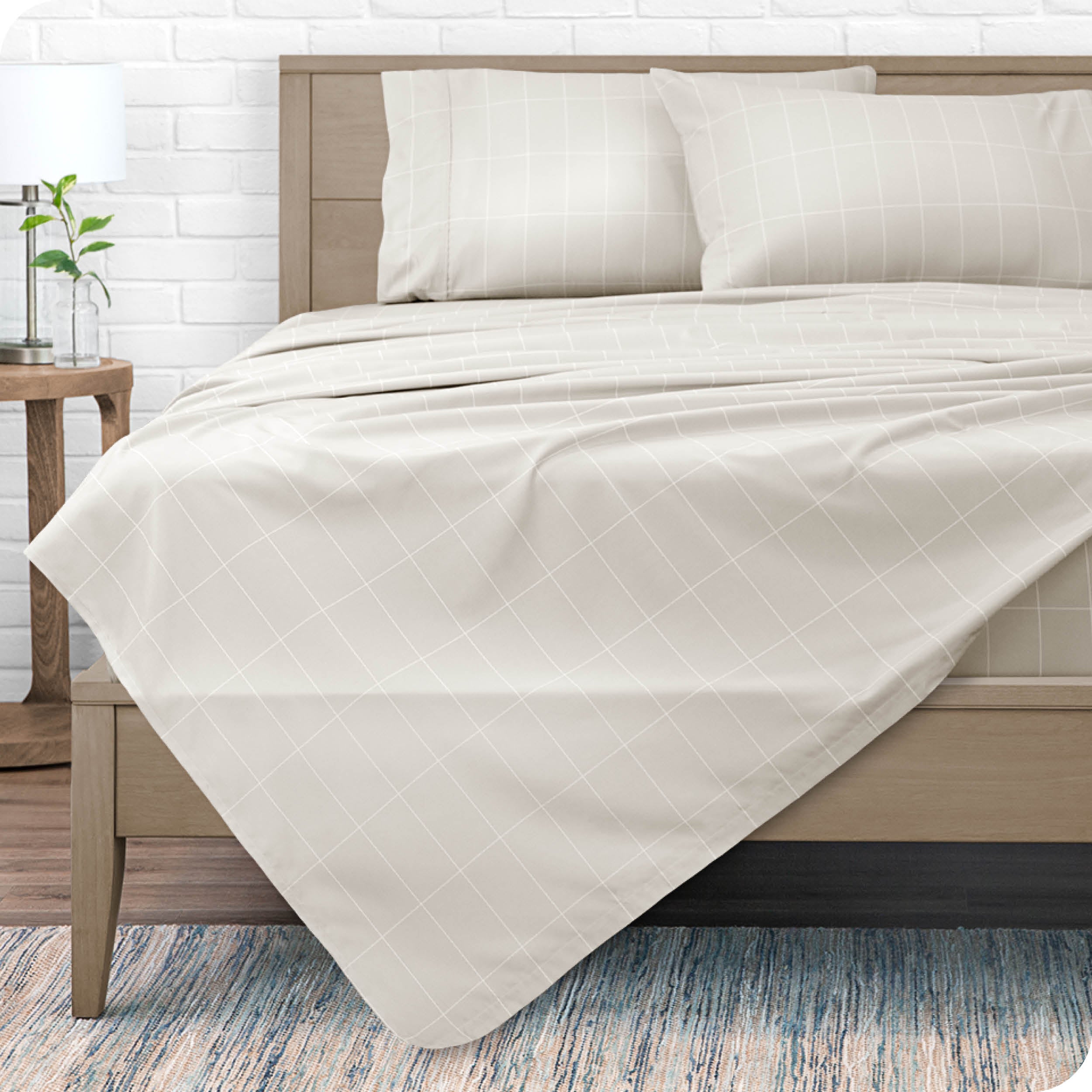 View from the end of a modern bed made with a microfiber sheet set with a modern print. 