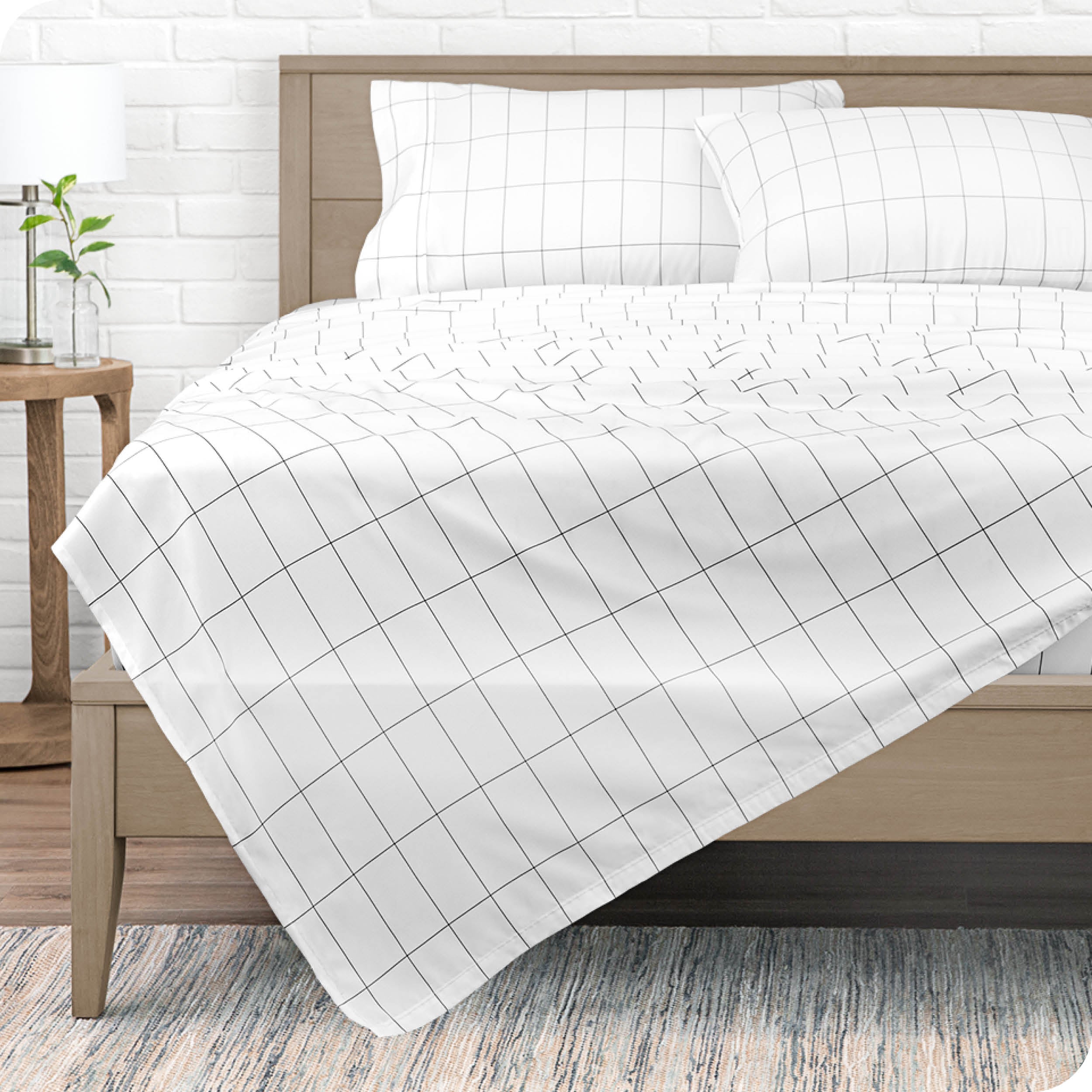 View from the end of a modern bed made with a microfiber sheet set with a modern print. 