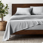 Luxury Linen Sheet Set is on a bed in a warm modern room.