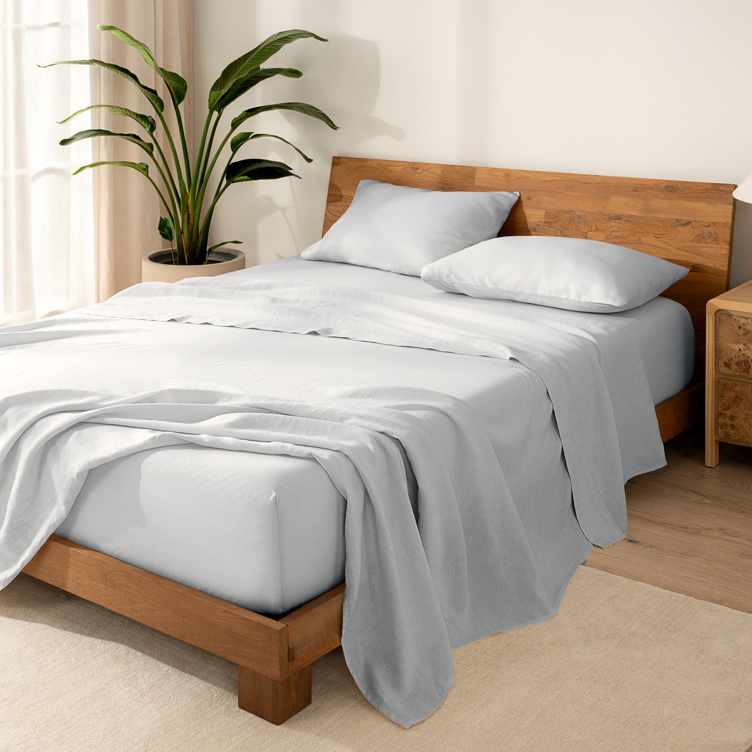 Wooden bed frame with  linen sheets on the mattress