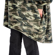 A man has a microplush wearable blanket on and his hands are in the side pockets