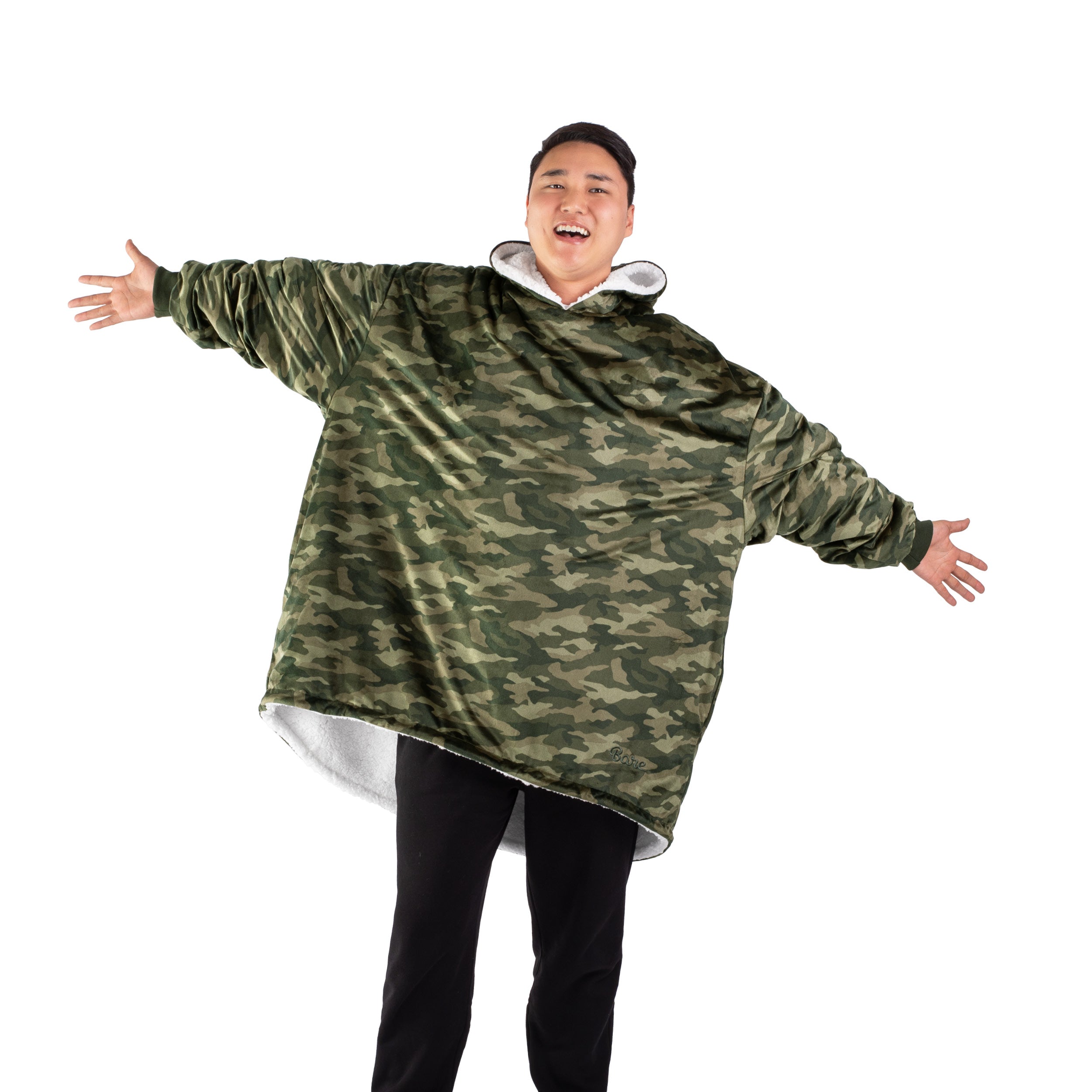 An adult with a hooded wearable blanket on