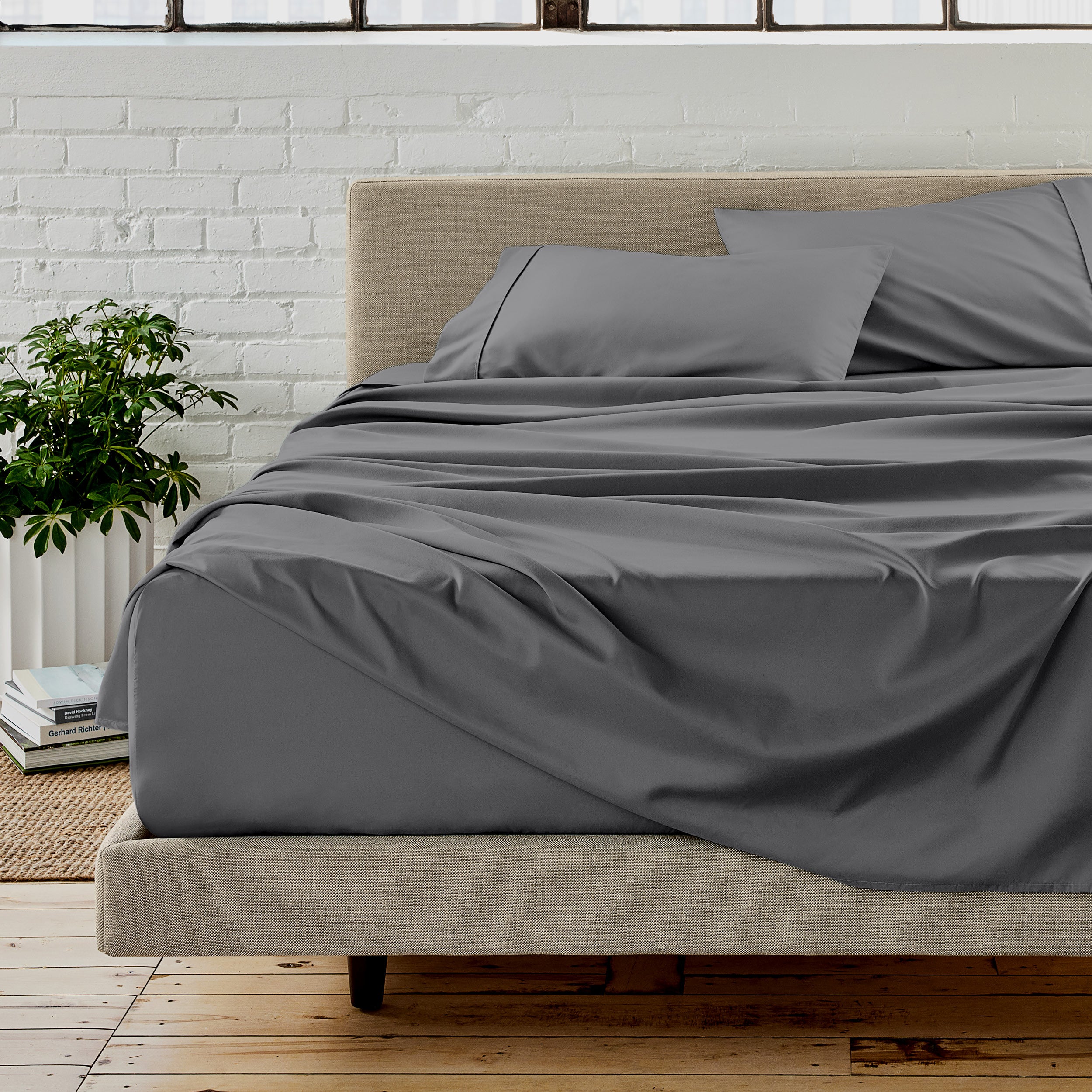 The sheet set with the matched same color pillowcases putting over the bed in a modern room.