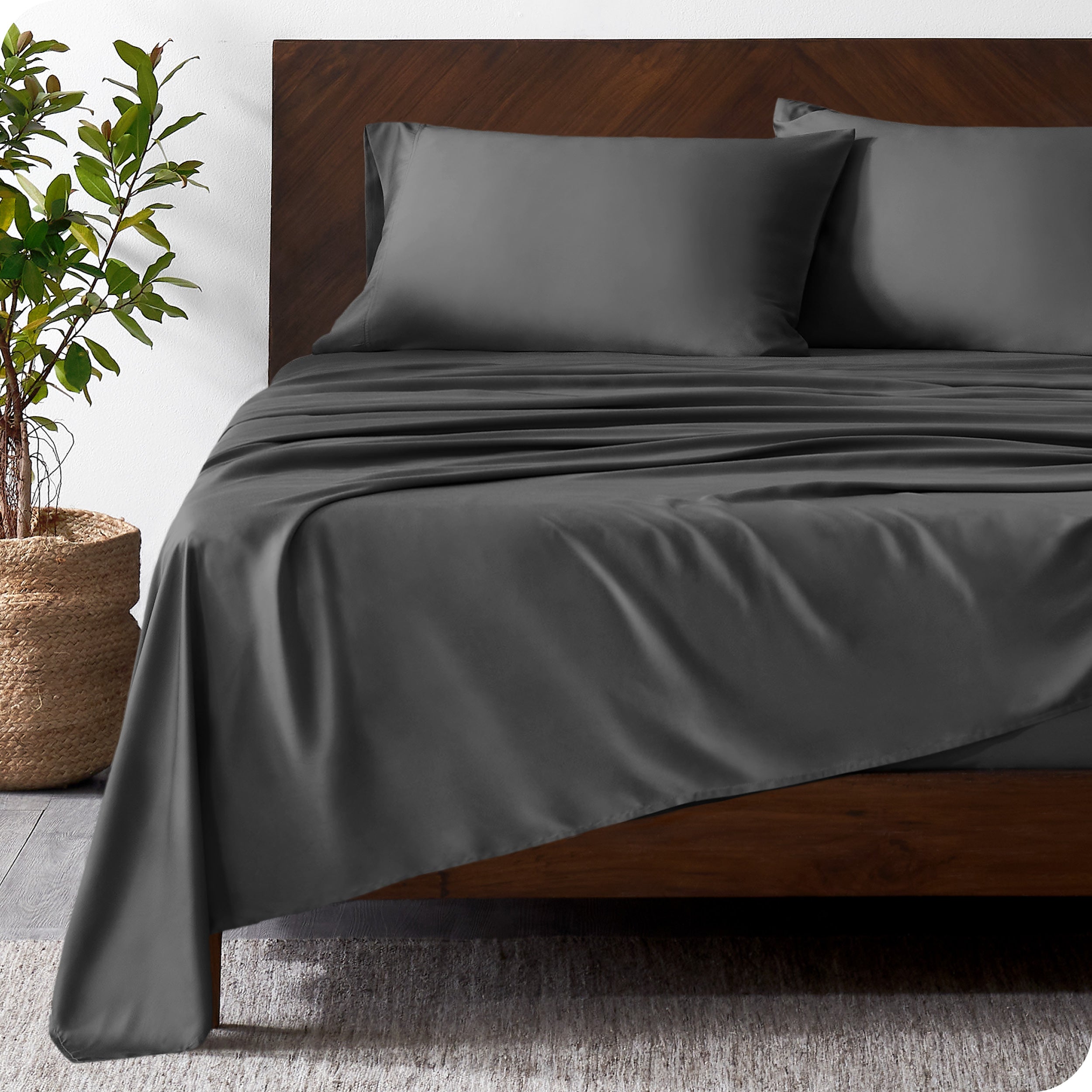 Wooden bed frame with bamboo sheets on the bed