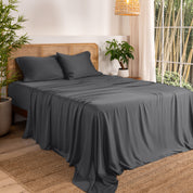 Bamboo sheets on a bed in a bedroom with plants and a window.