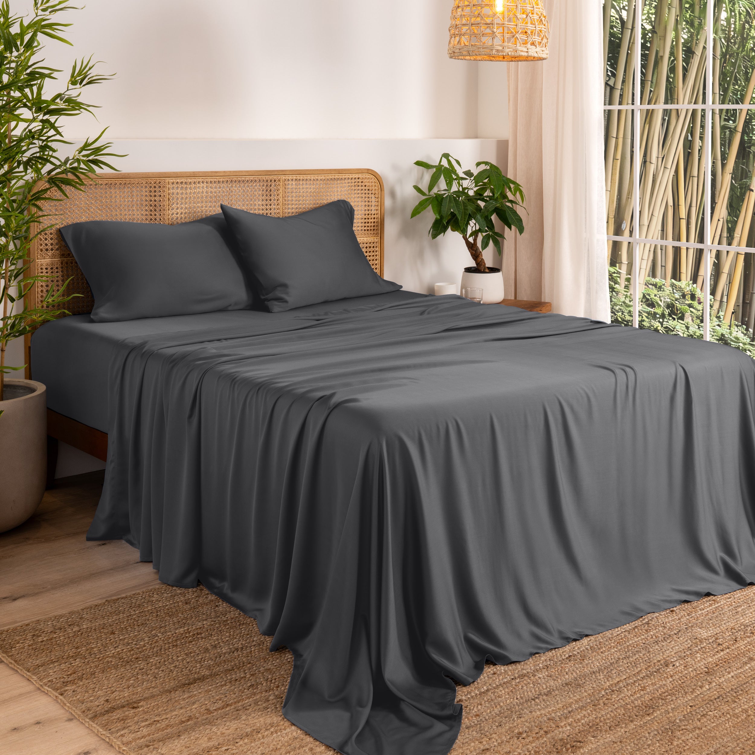 Bamboo sheets on a bed in a bedroom with plants and a window.