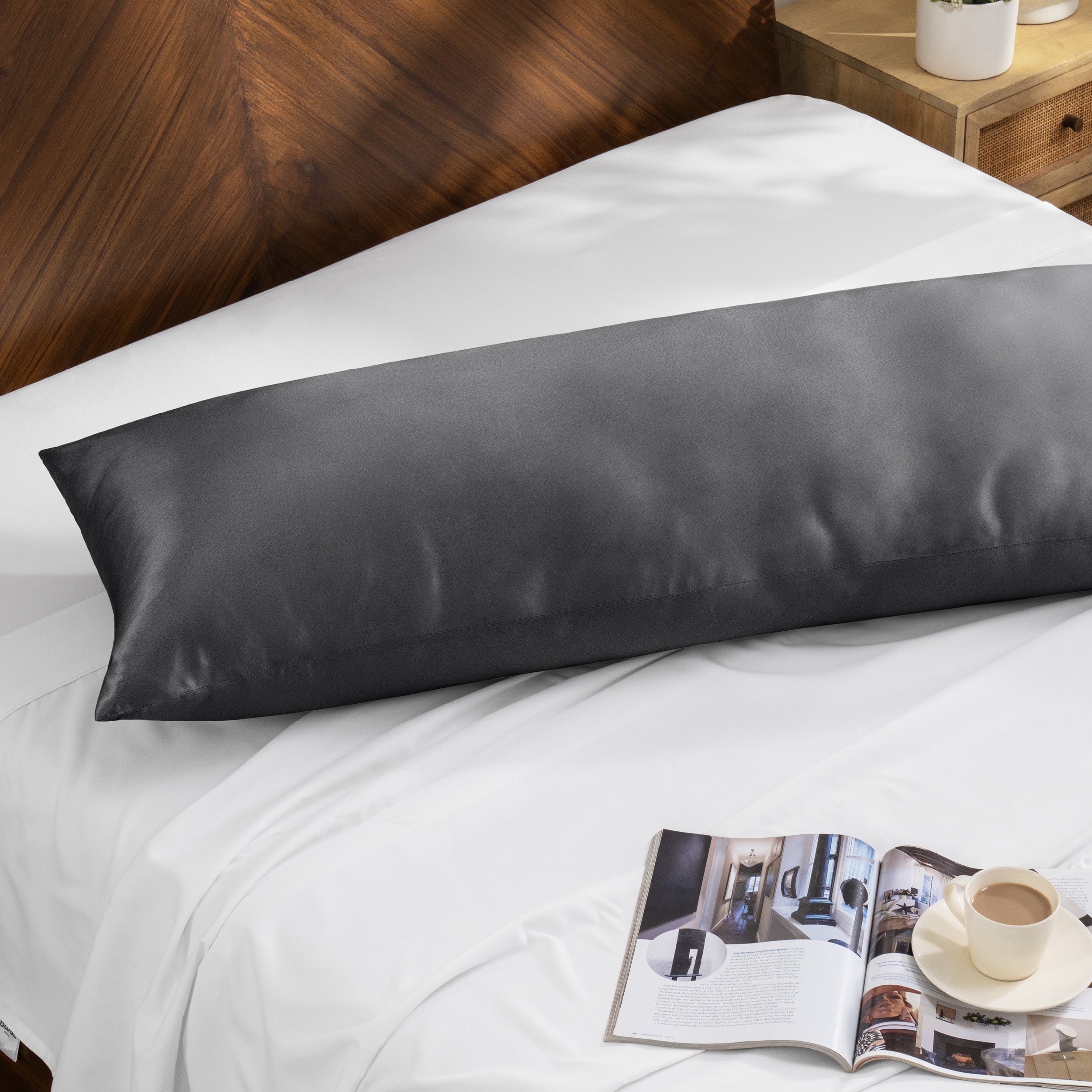 Bamboo body pillow on a bed with a magazine and cup of coffee nearby.