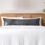 Bamboo body pillowcase on a bed with white bedding and a wicker headboard.