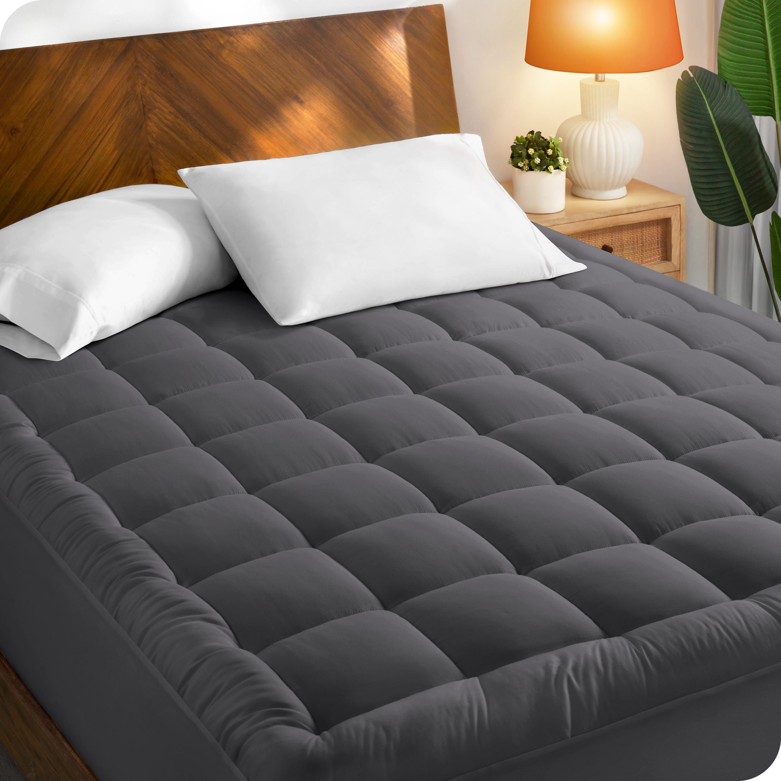 A mattress pad on a bed with a wooden headboard