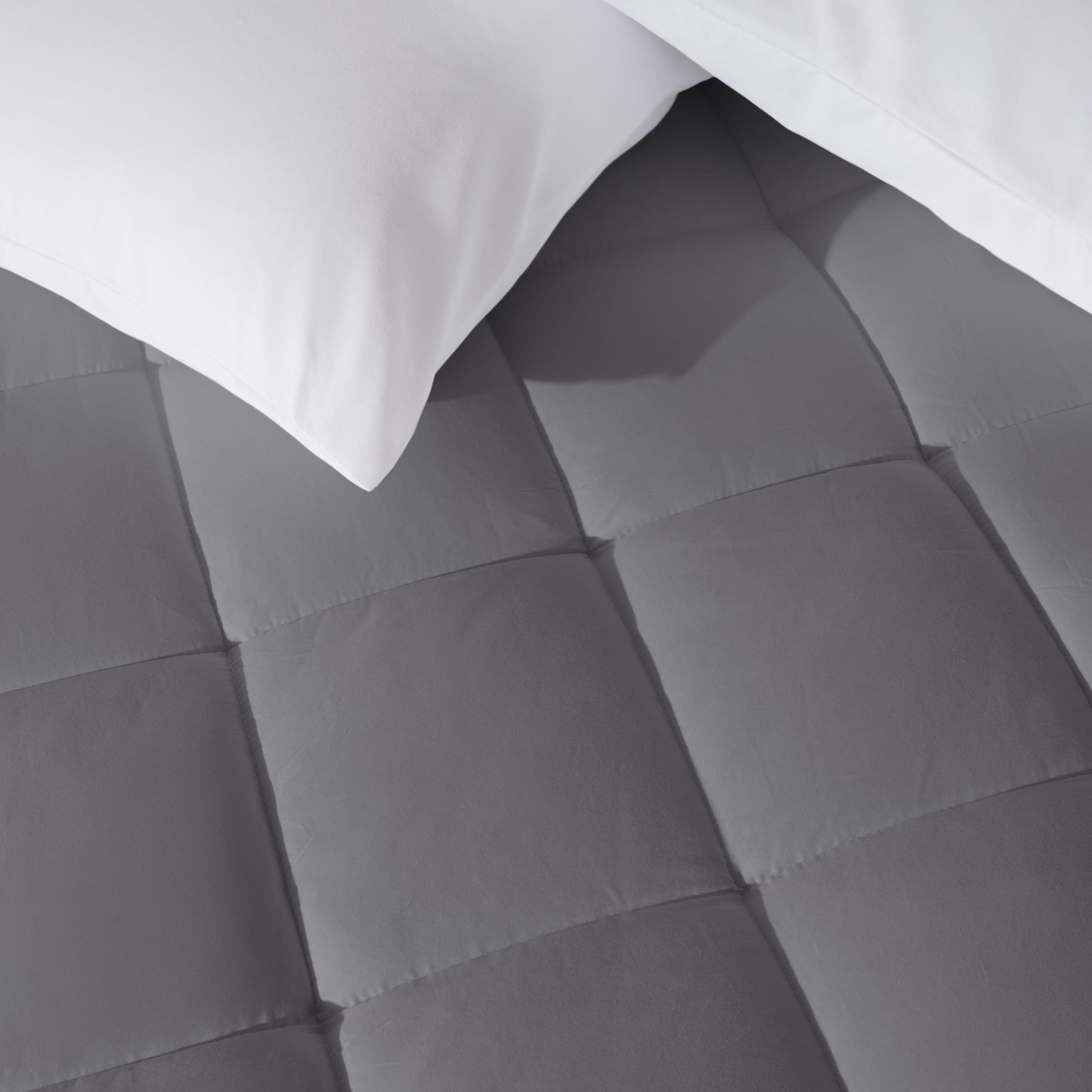 Close up of a cotton top mattress pad with pillows from above.
