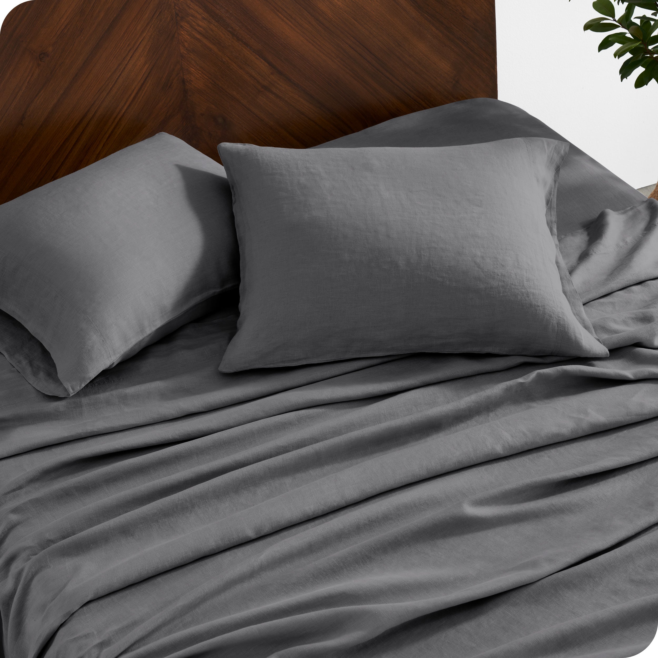 Close up of linen sheet set on a mattress with pillows inside the pillowcases