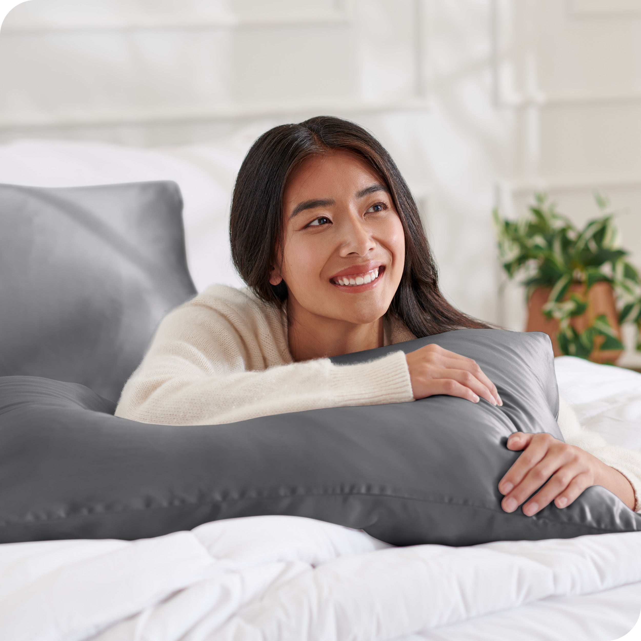 A woman on a bed with her arm resting on a pillow