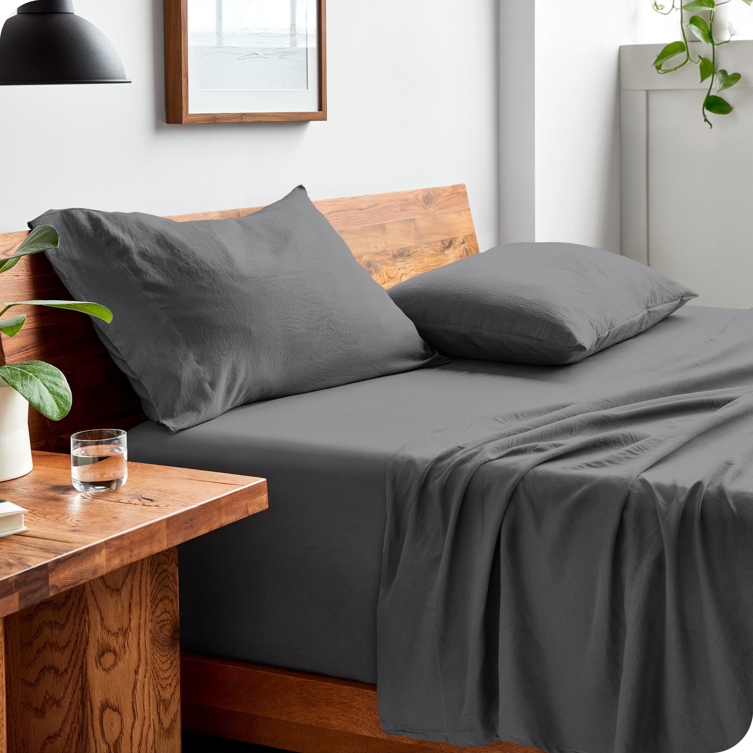 Side view of bed made with fitted sheet, pillowcases, and top sheet