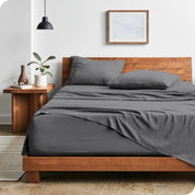Modern bedroom with Sandwashed sheets draped over the end and side of mattress

